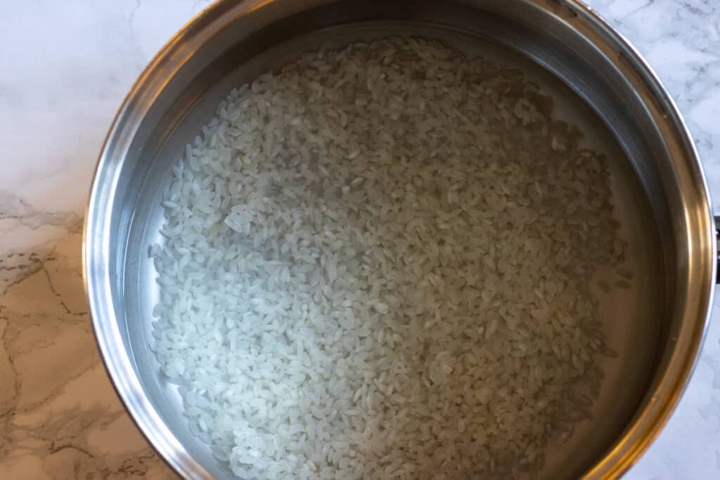 Rice and water in a pan.