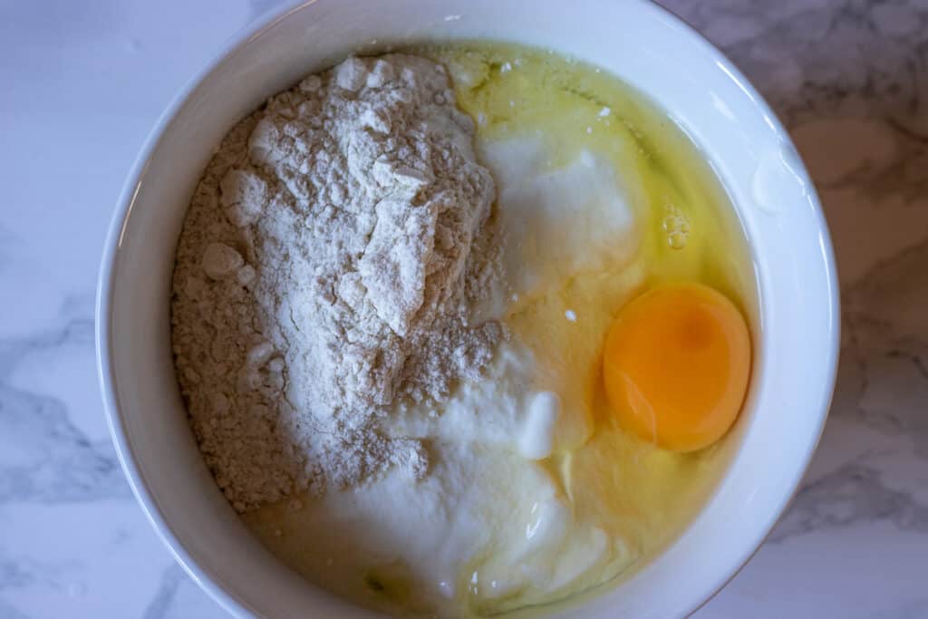 Egg, yogurt, and flour in a mixing bowl.