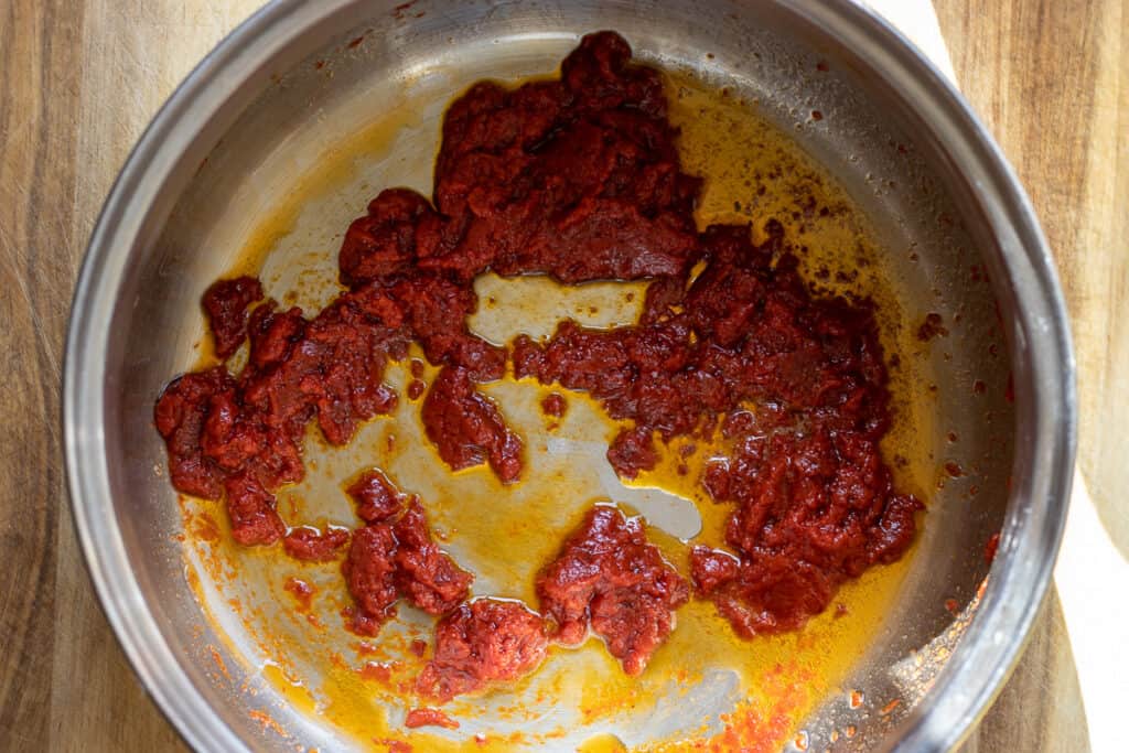 Sautéing the pepper paste with butter in a pan.