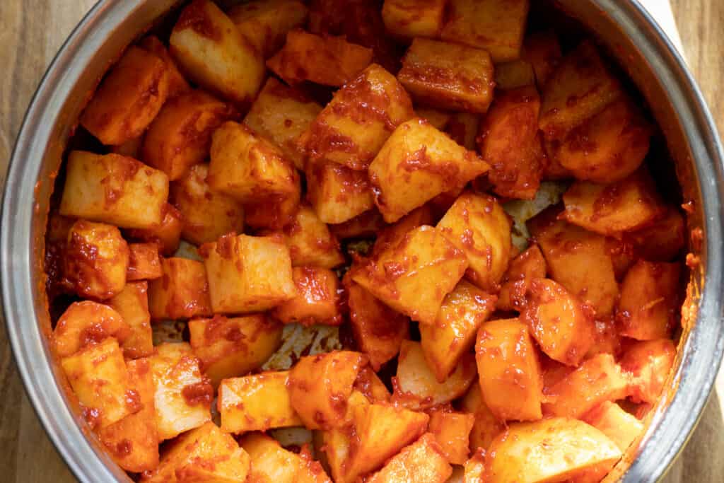 Potatoes and carrots are added to the pan.