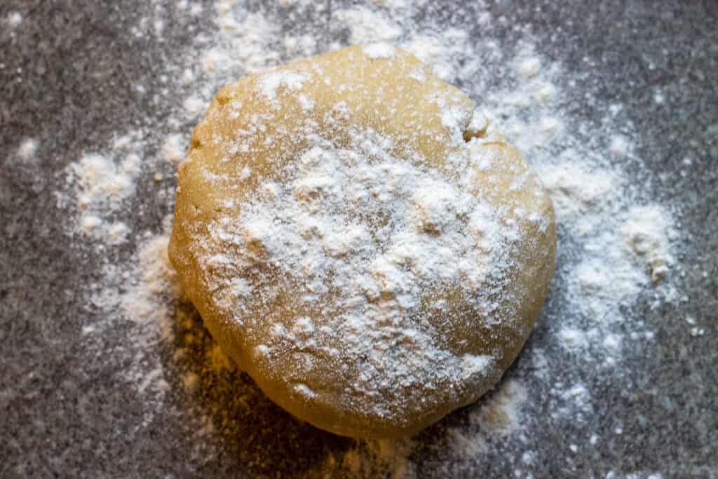The dough is placed on a lightly floured surface.