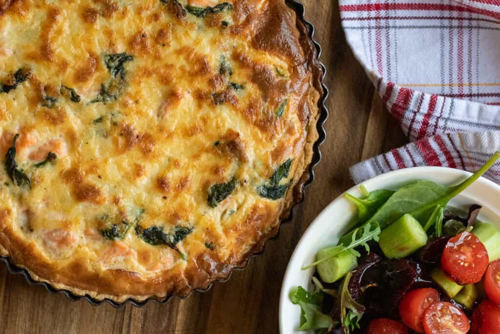 salmon and spinach quiche served with salad