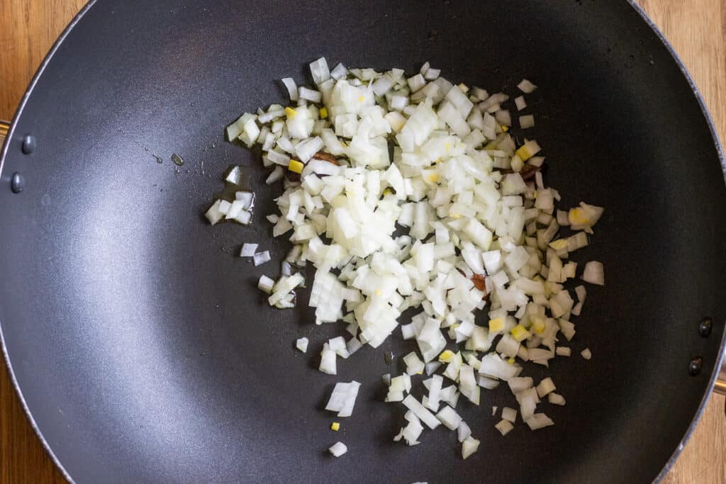 Chopped onions are in a pan for sautéing.