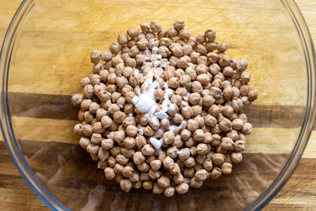Chickpeas and bicarbonate of soda in a glass bowl.