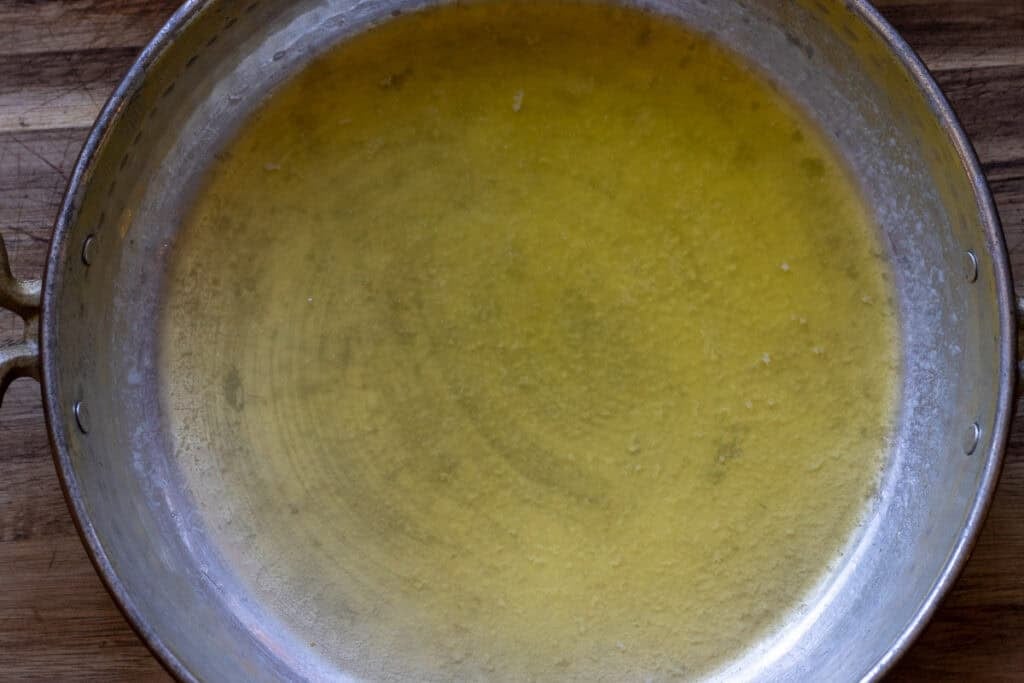 Butter melting in a copper sahan.