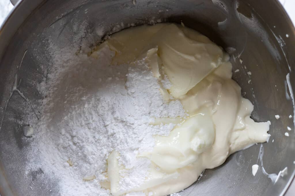 Sour cream and icing sugar are placed in a mixing bowl.
