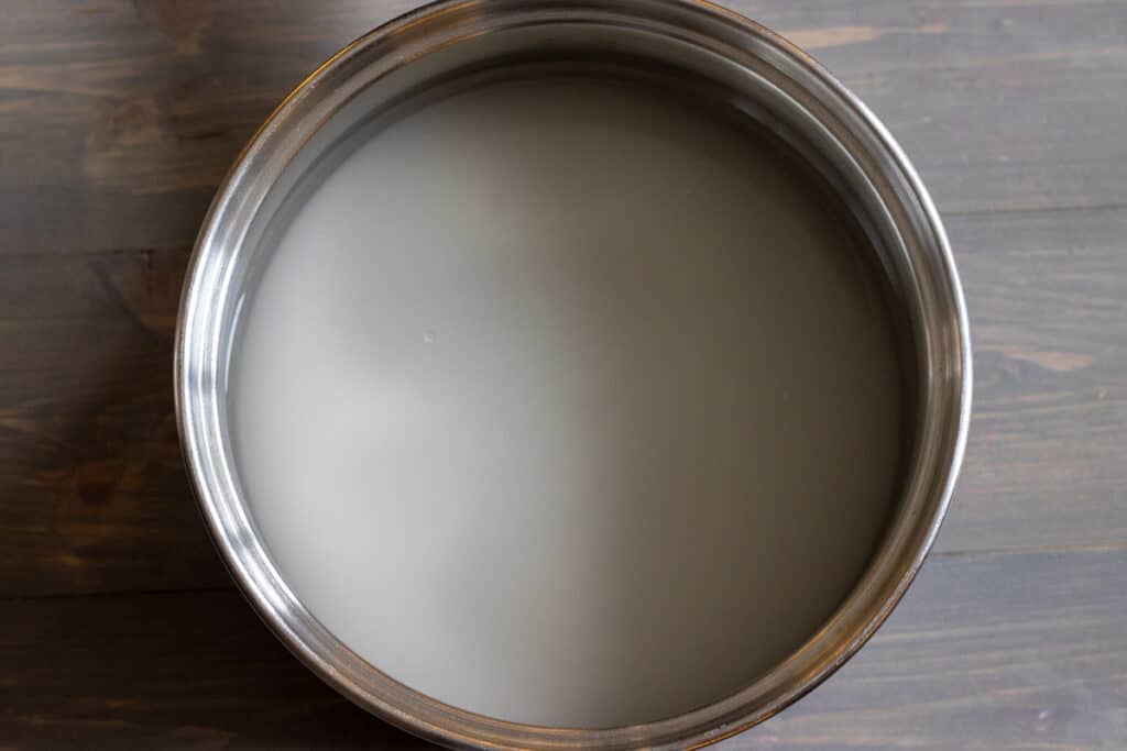 Water and sugar are placed in a pan for making syrup.