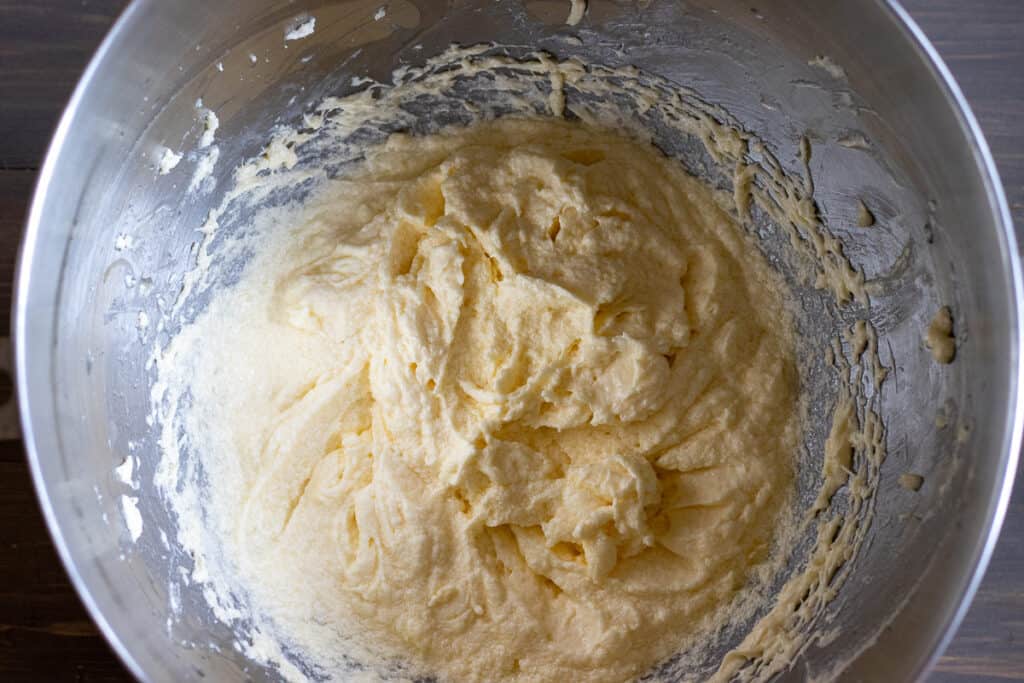 Eggs are added to the beaten butter and sugar.