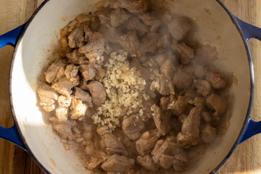 Onions and garlic cooking with the browned lamb.