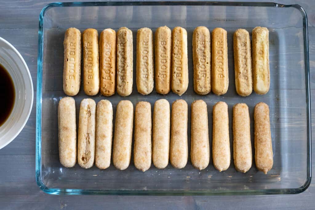 Ladyfingers dipped in coffee and arranged in the bottom of the dish.