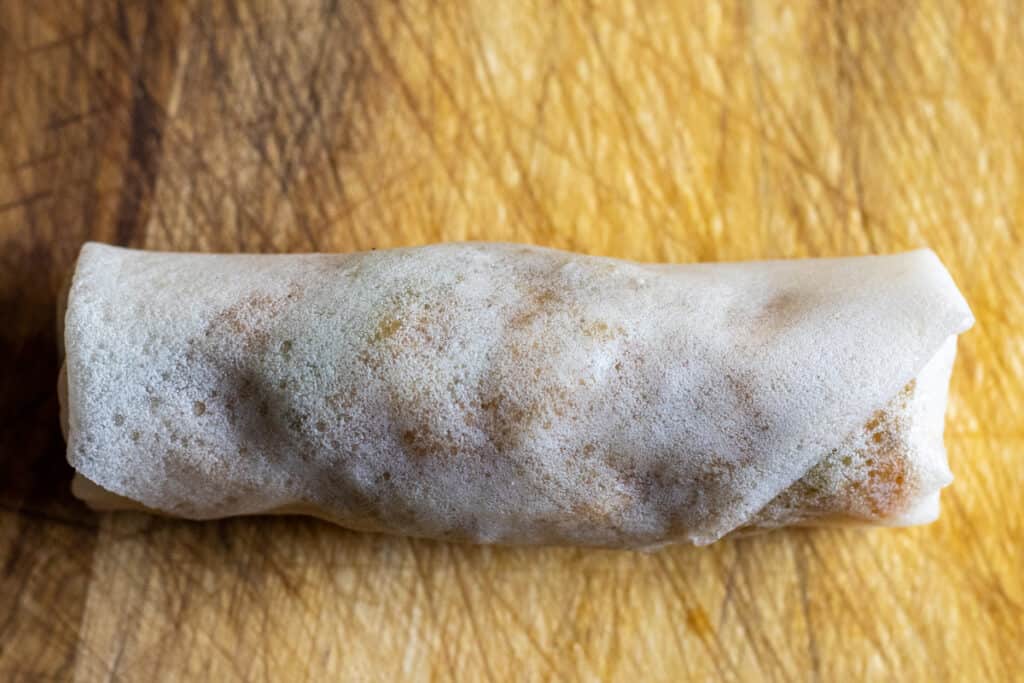 Flour and water mixture brushed onto the final corner of a duck spring roll wrapper to seal it.