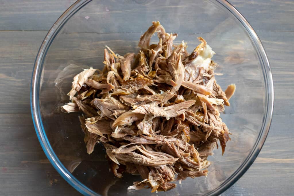 Shredded roast Pekin duck in a large glass bowl.
