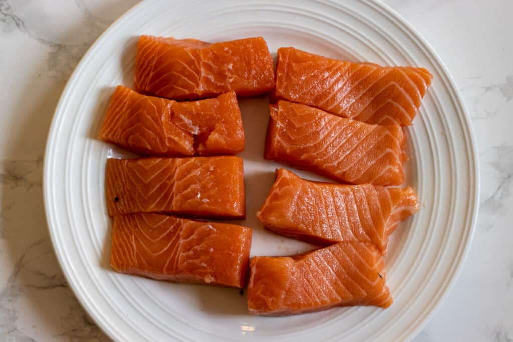 8 pieces of salmon on a plate.