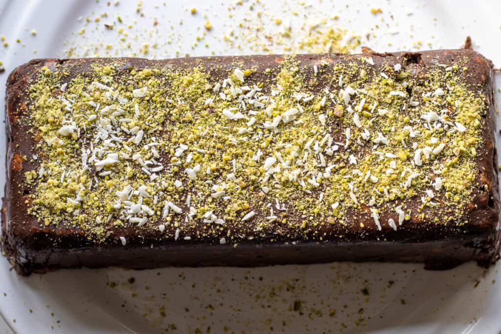 The cake is transferred to a serving plate after freezing.