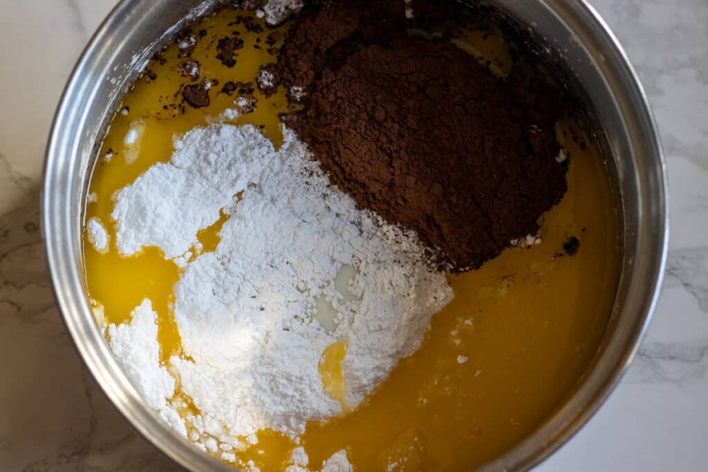Milk, butter, sugar, and cacao powder are placed in a pan.
