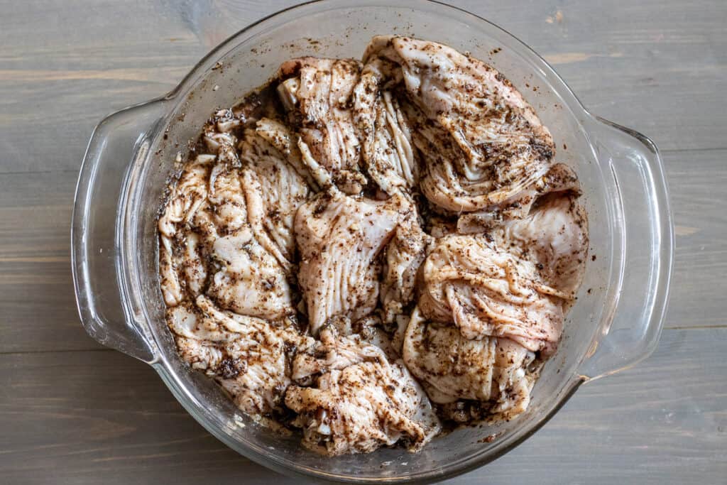 Chicken pieces are covered with marinade.