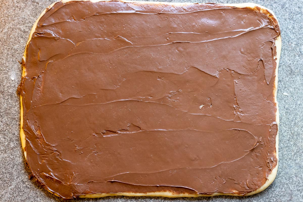 Nutella spread over the rolled dough.