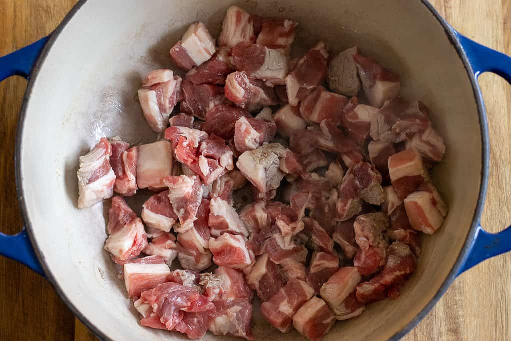 Sautéing the diced lamb with olive oil in a pan.