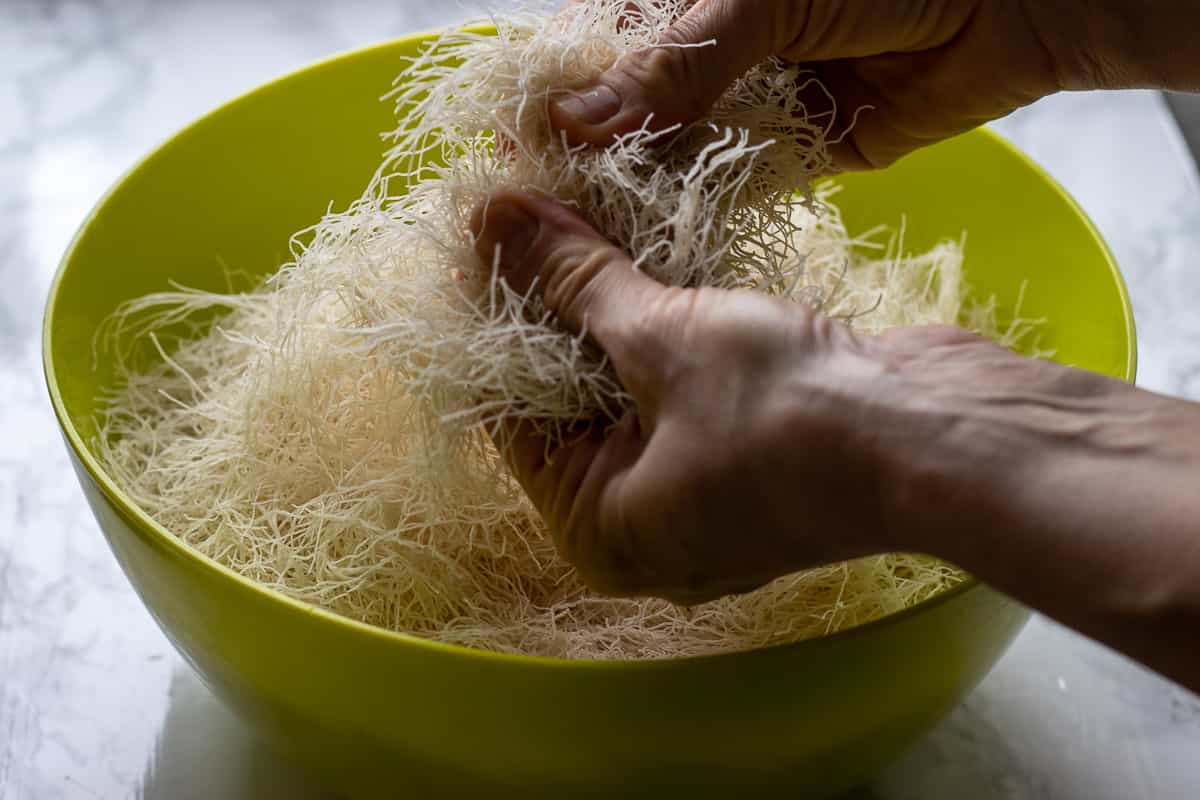 Seperating the kadayif pastry strands with fingers.