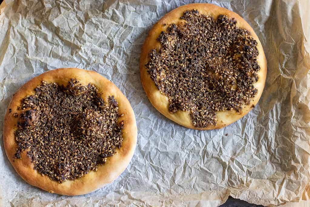 Two baked za'atar manakish with golden edges.