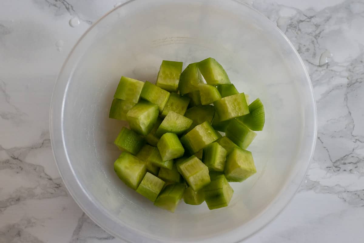 Peeled, diced cucumbers in a clear bowl.