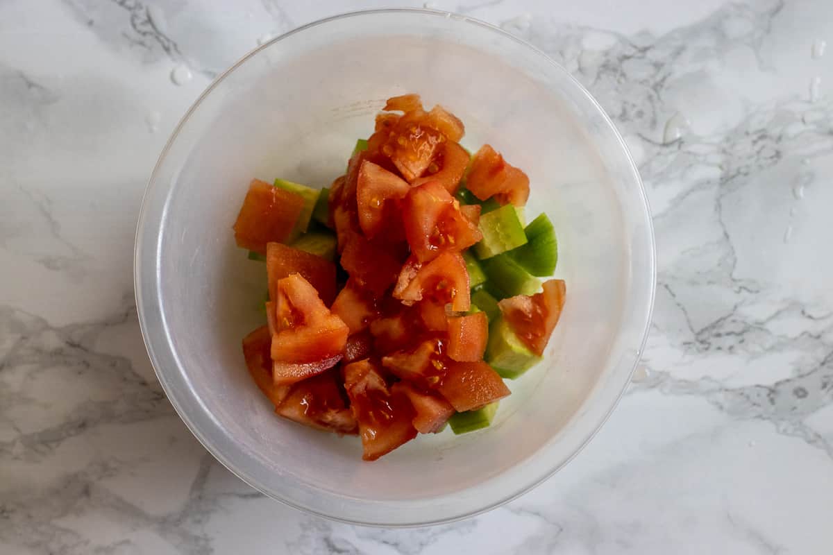 Diced tomatoes added on top of the cucumbers.