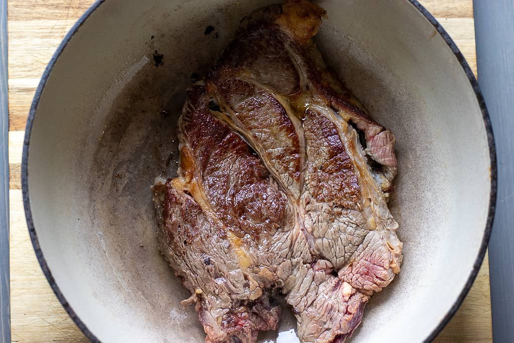 Browning the chuck roast in a Dutch oven.