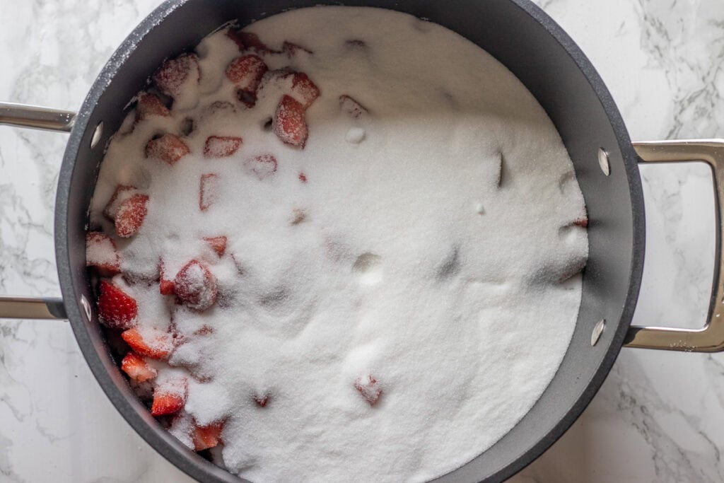 Chopped fruits are covered with sugar.