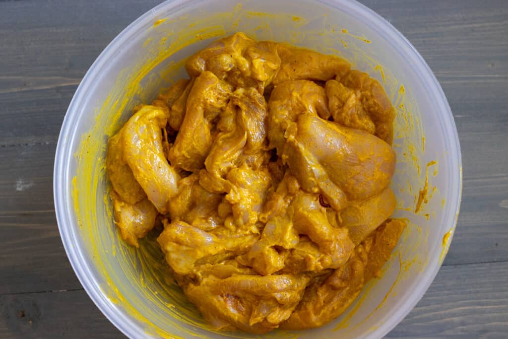 Boneless chicken thighs coated in the yogurt marinade.