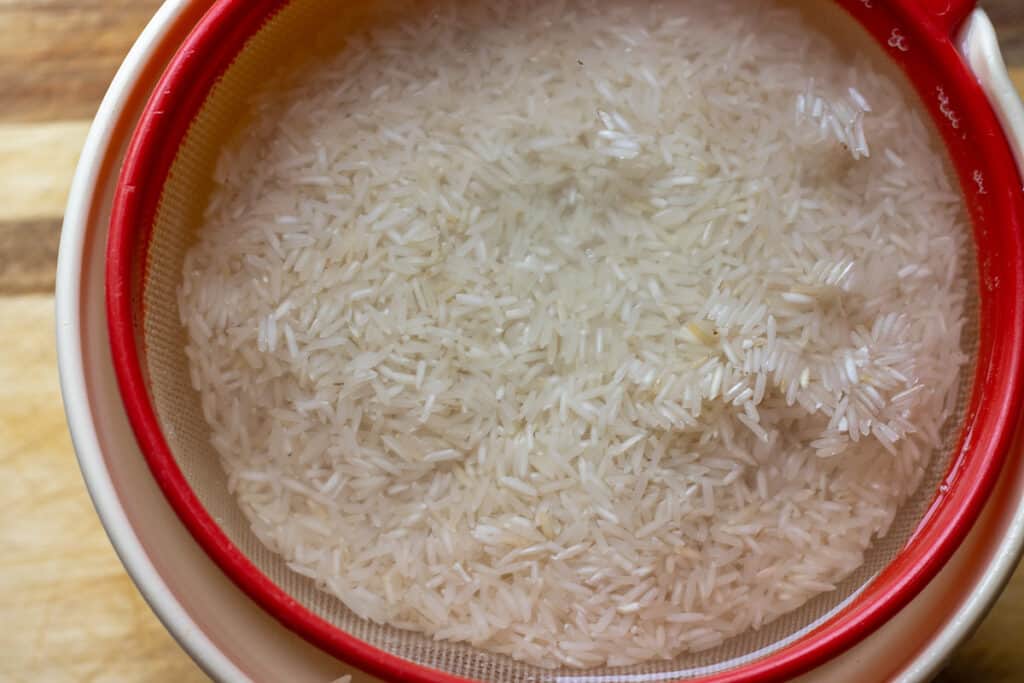 Washing the rice in a colander.