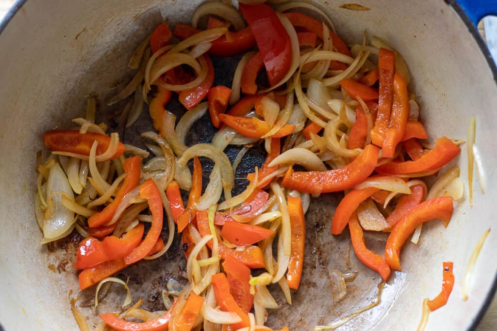 Sautéing onions and peppers in a Dutch oven.