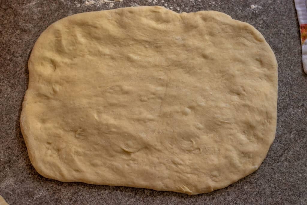A dough ball is rolled out into a rectangle.