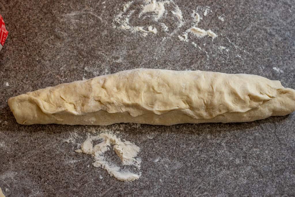 The dough is shaped into a log, the shape of a baguette.