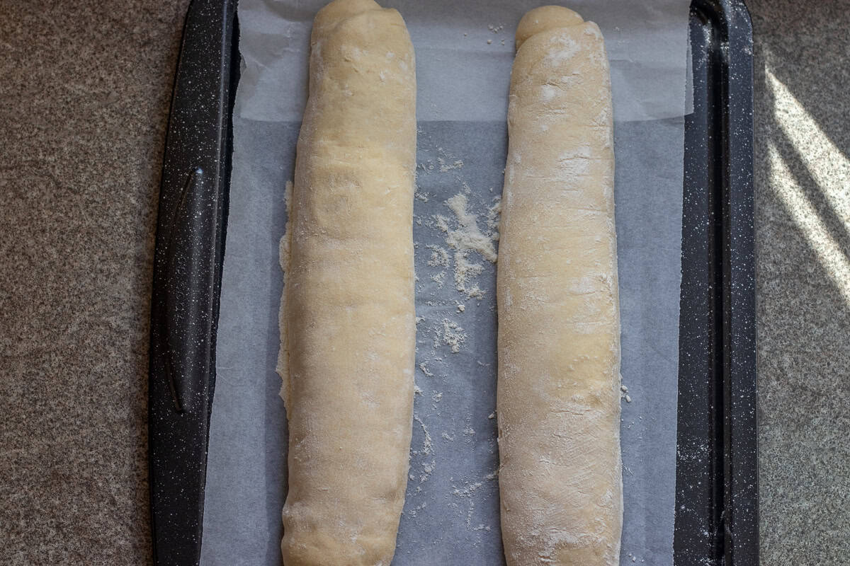 2 bread loaves on a parchement paper lined tray.