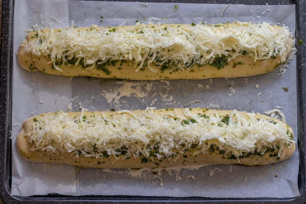 2 bread loaves topped with cheese mixture.