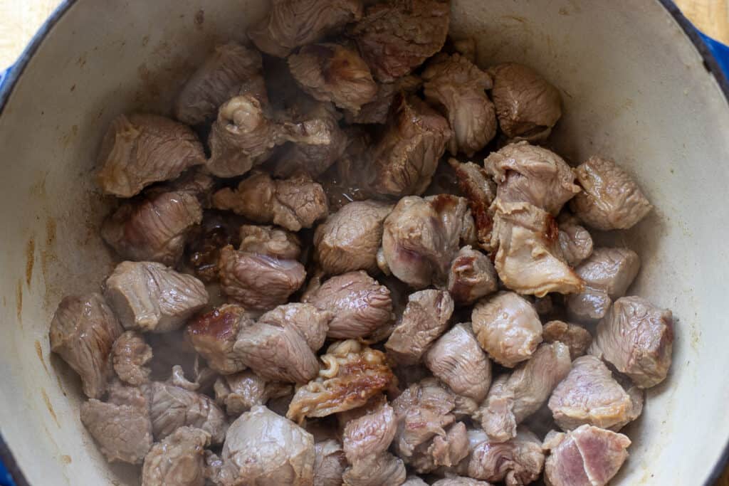 Sautéing the lamb in a Dutch oven.