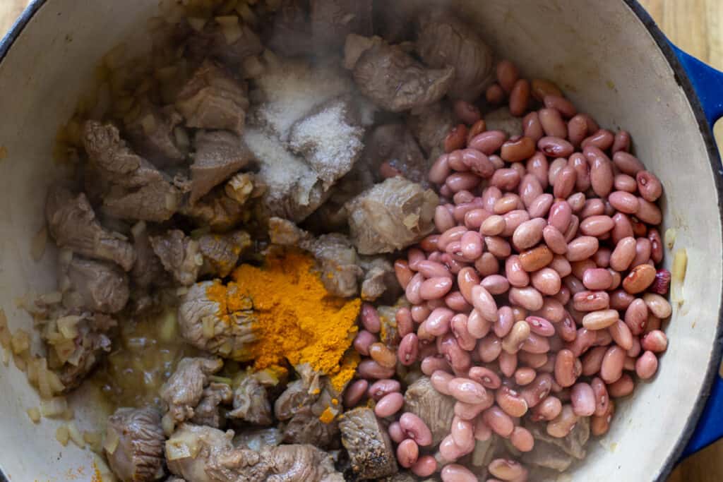 Red kidney beans, salt, pepper, and turmeric added to the pot.