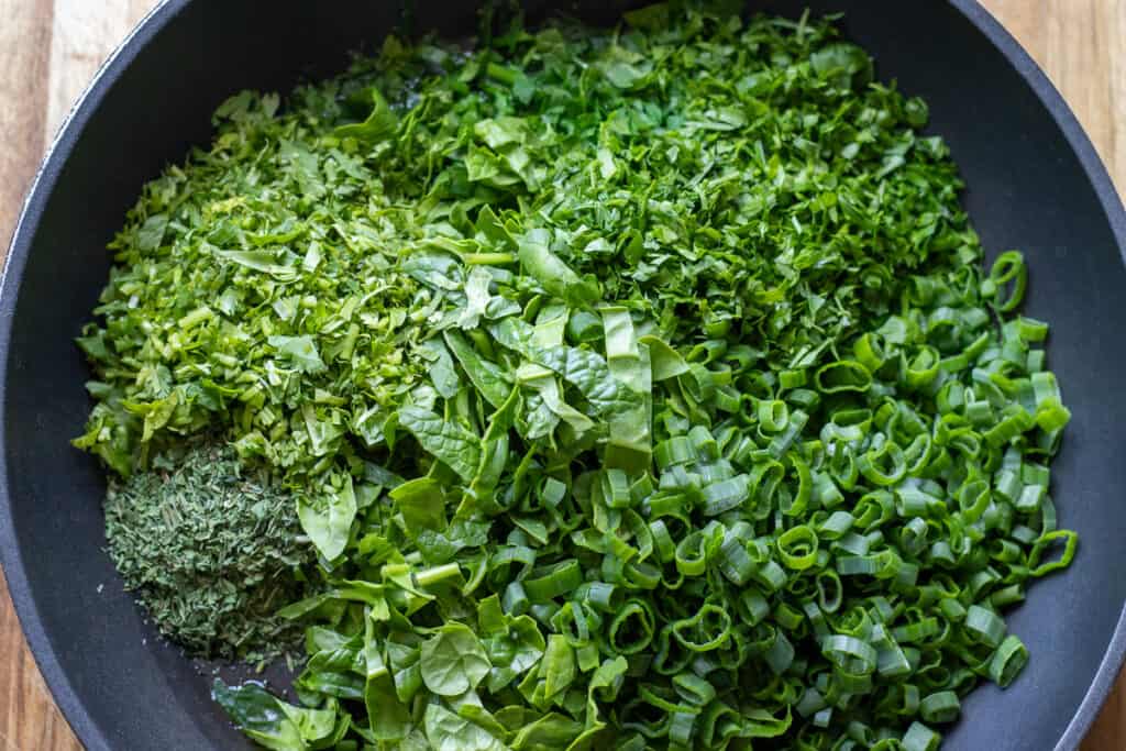 Chopped herbs placed in a pan.