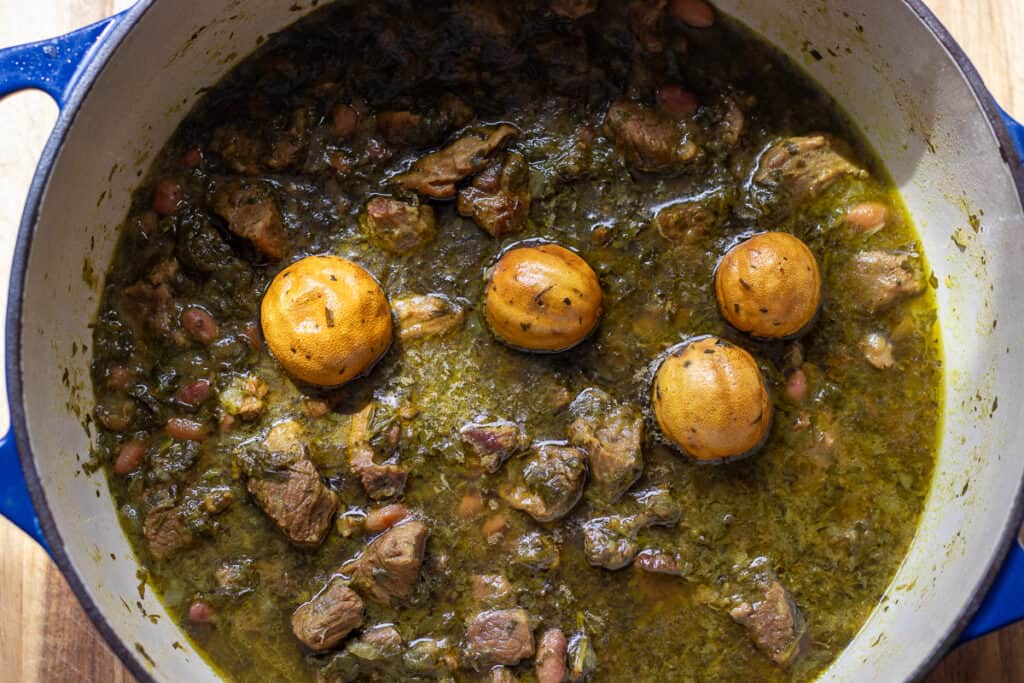Dried limes simmering on top of the stew in a Dutch oven.