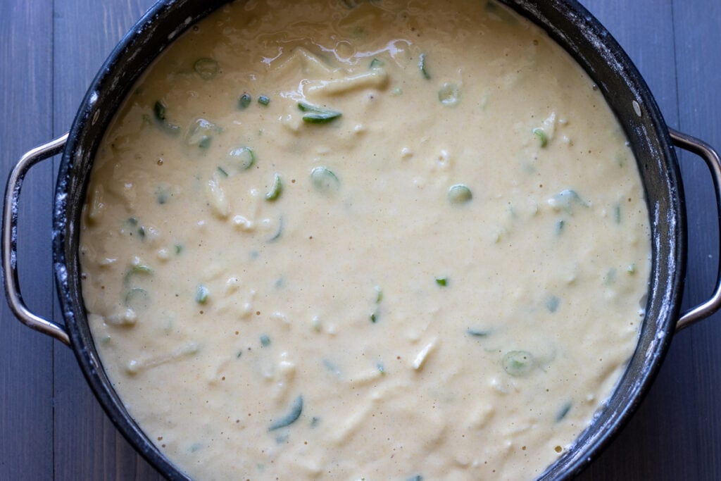 Cornbread batter poured into a springform cake pan.