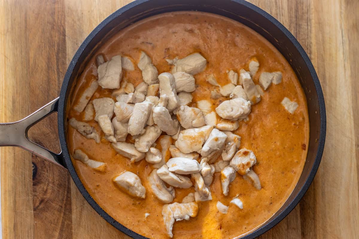 Seared chicken pieces simmering in the creamy sauce.