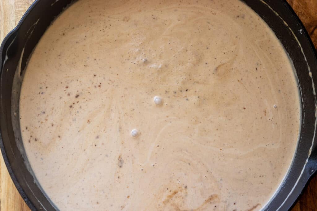 Heavy cream is added to the pan.