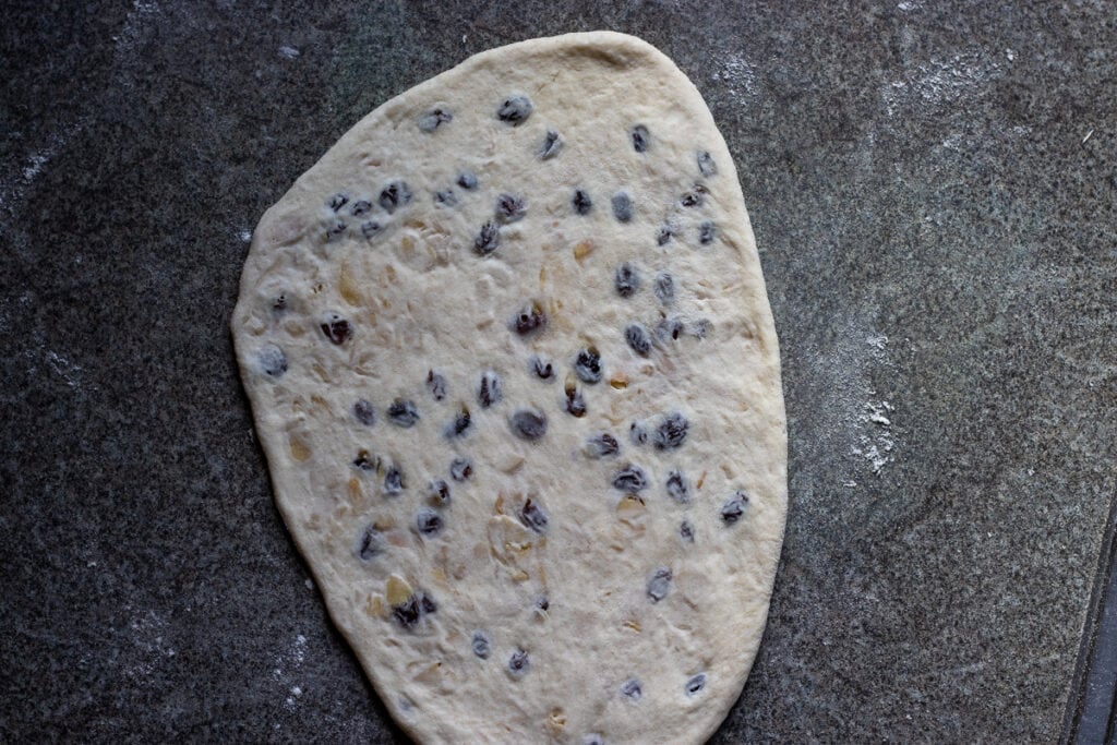 The stuffed dough ball is shaped into a naan bread.
