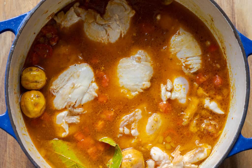 The stock and chicken pieces are added to the pan.