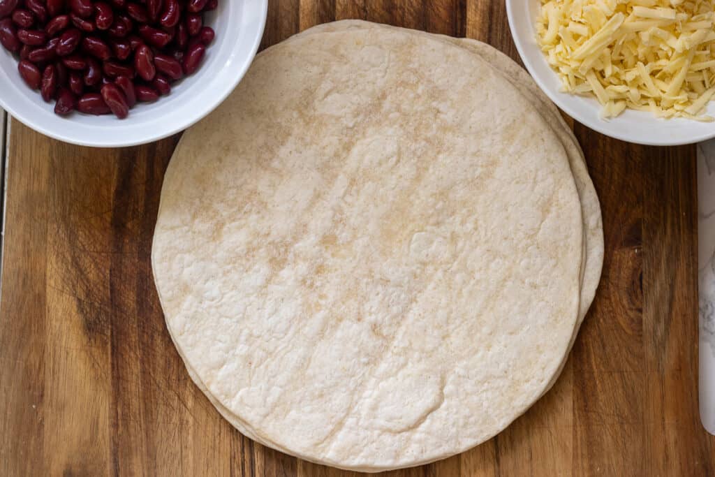 A tortilla wrap is placed on a clean surface for making burritos.