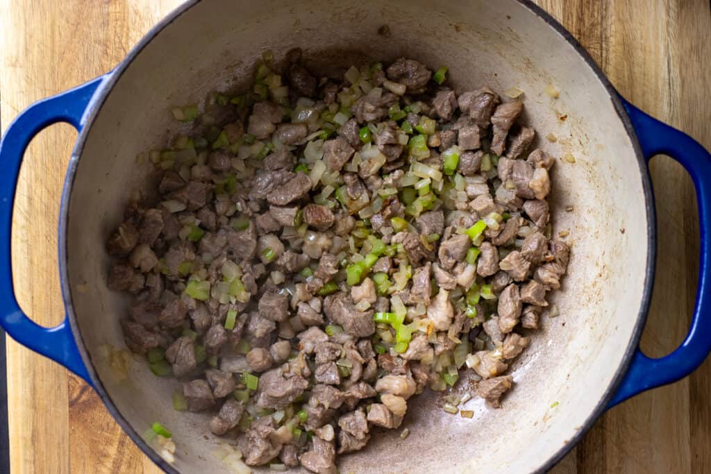 Sautéing onions, celery, and garlic with the lamb.
