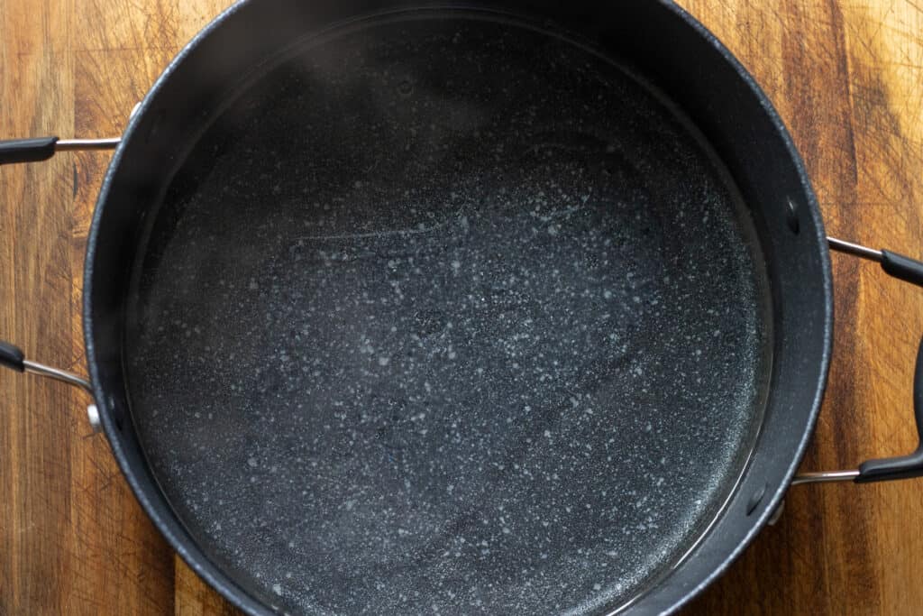 Boiling water and oil are poured in a saucepan.