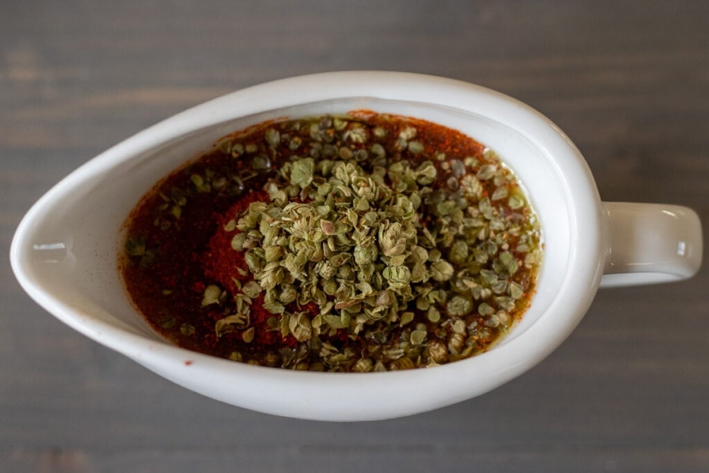 Olive oil, milk, paprika, dried herbs, salt, and black pepper are mixed for the marinade.