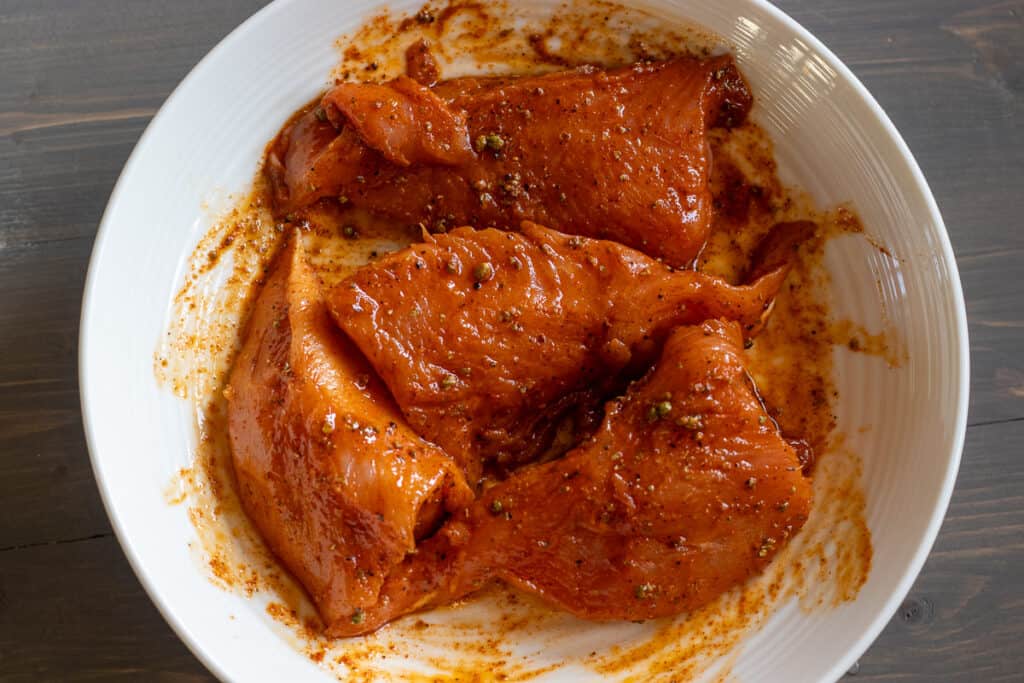Turkey tenderloins coated in marinade before cooking.
