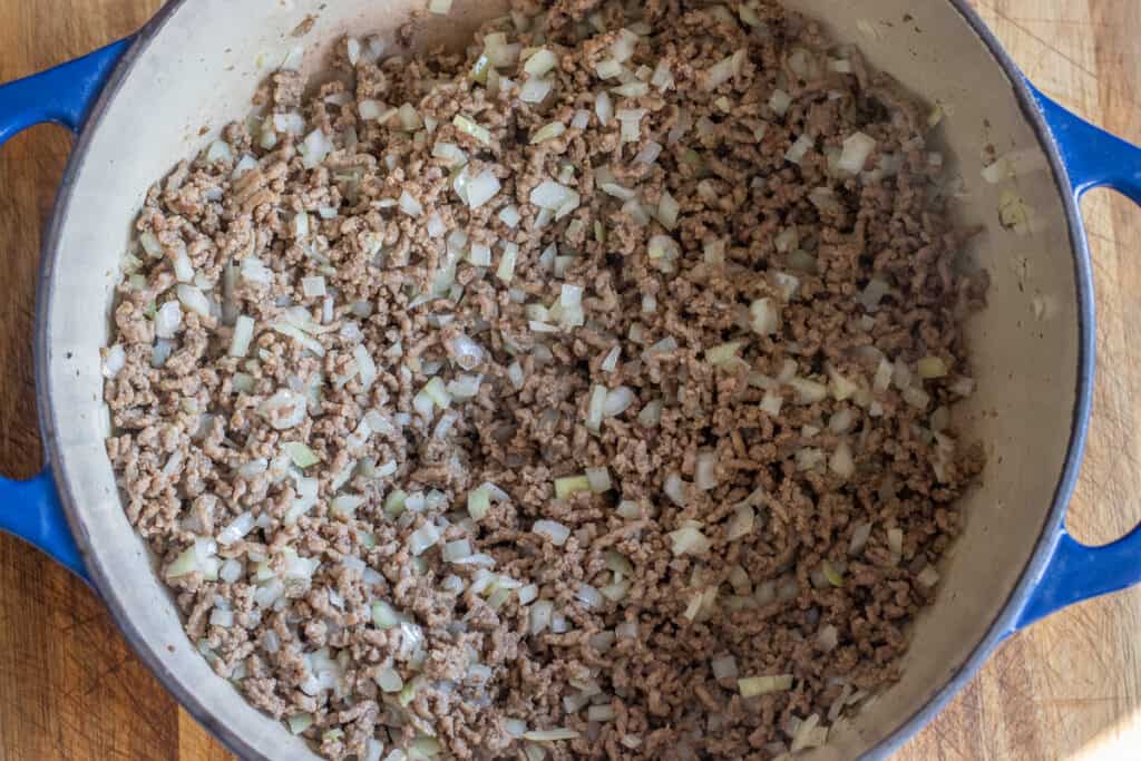 Sautéing the onions and garlic in a Dutch oven.